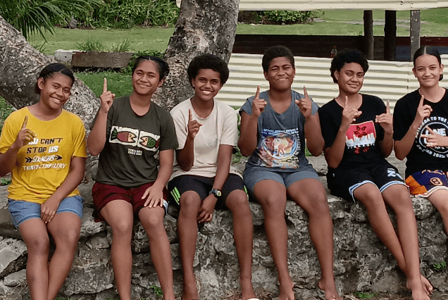 A group of young people sitting together outdoors in Fiji