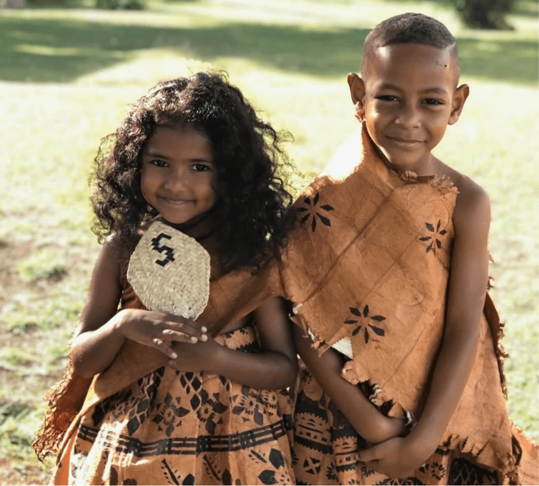 Two Fijian children wearing traditional clothing outdoors