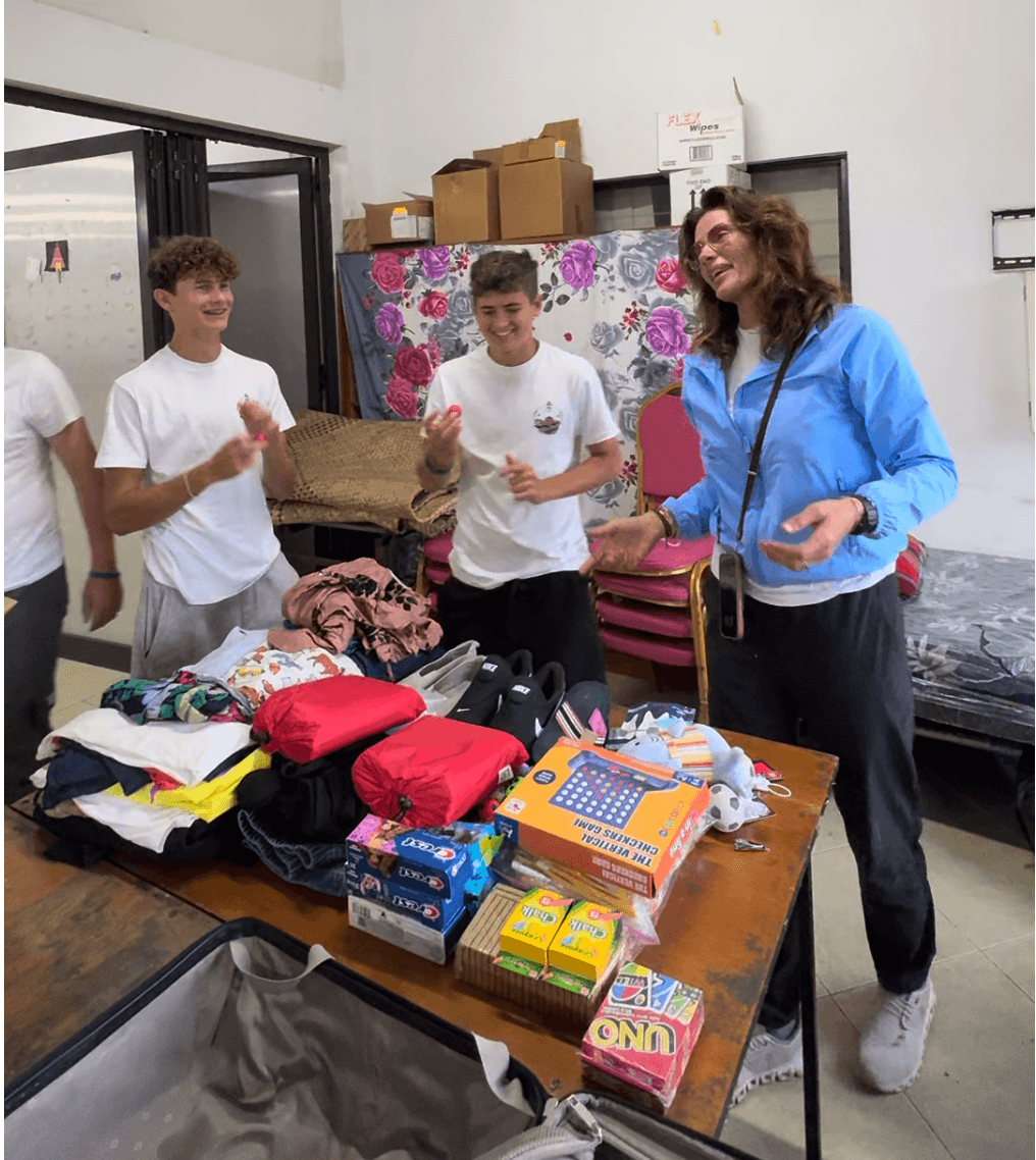 OOCSA volunteers organizing donated clothing, shoes, games, and supplies for children