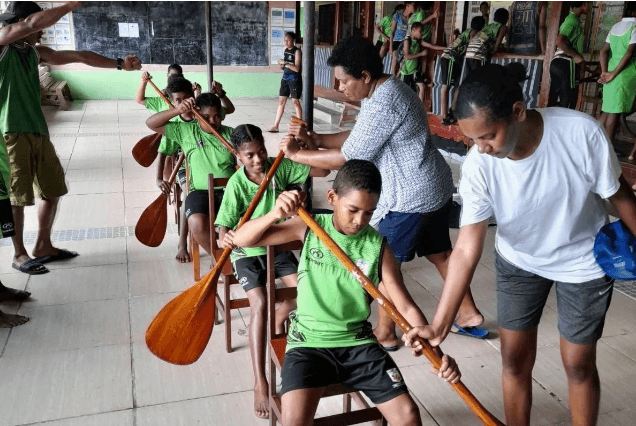 Young people practicing outrigger paddling technique